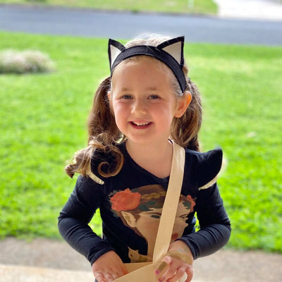 Child wearing black felt cat ears as part of a dress-up costume for book week