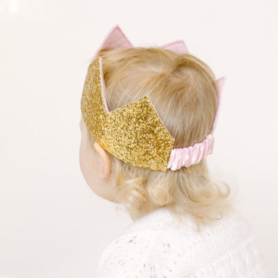 gold birthday crown  on a child head showing the elastic casing at the back