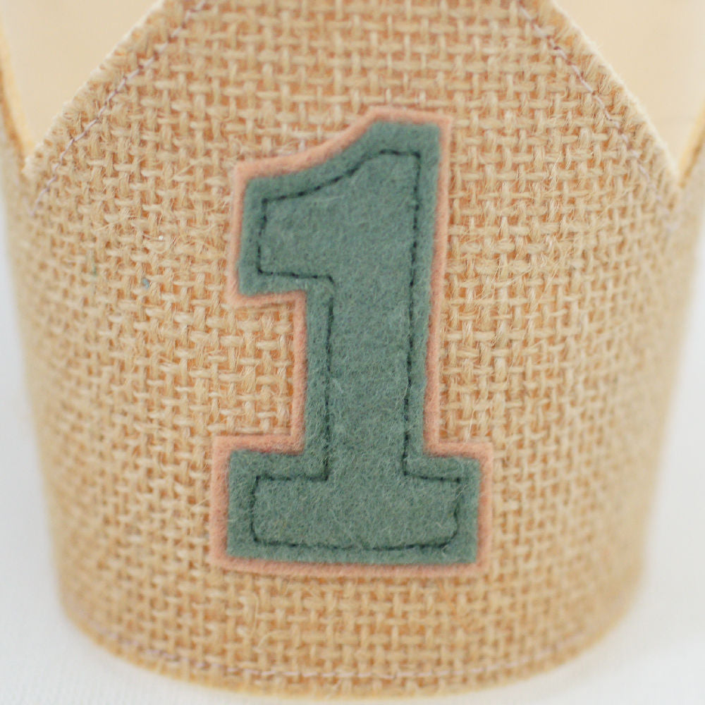 close up of the green olive felt 1 stitched on the front of the hessian first birthday crown