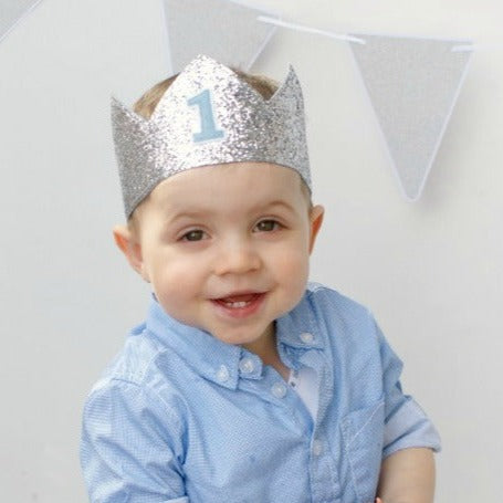 first birthday boy in his silver glitter crown and blue shirt